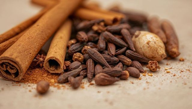 Warm spice mix with cinnamon sticks, cloves and star anise closeup macro still life