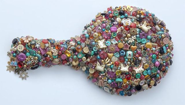 Paddle-shaped craft mosaic featuring vibrant buttons, beads, pearls and rhinestone charms