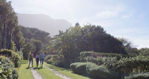 Female Friends Walking Along Picturesque Garden Path