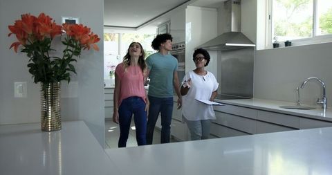 Real estate agent showing young couple a modern kitchen