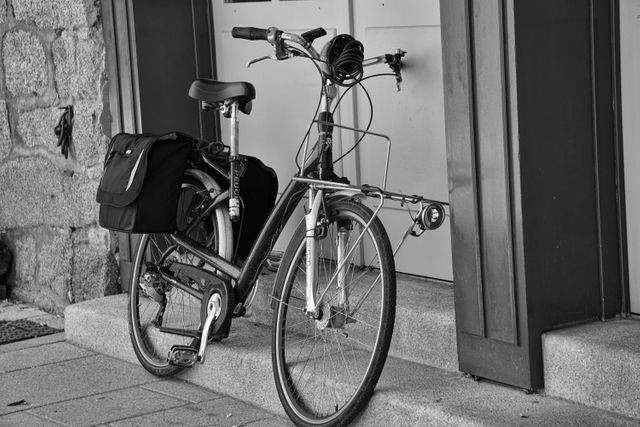Classic vintage bicycle leaning against doorway suggesting urban transportation or lifestyle. Ideal for illustrating themes related to city life, retro objects, transportation, commuting, and outdoor activities.