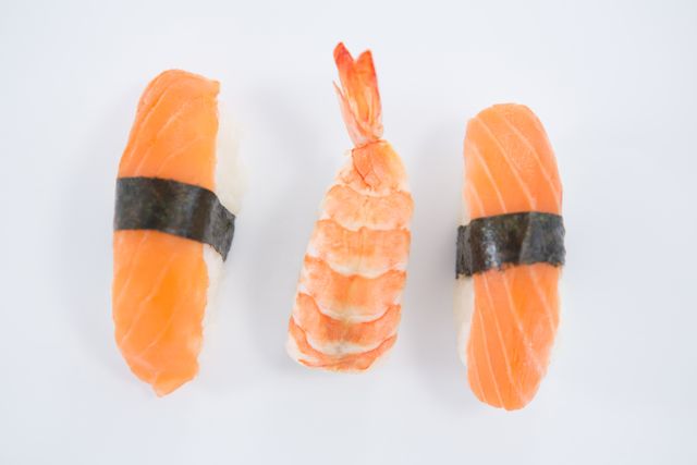 Close-up of sushi nigiri and shrimp on a white background. Perfect for use in food blogs, Japanese cuisine promotions, restaurant menus, and culinary magazines. Highlights the freshness and simplicity of traditional sushi.
