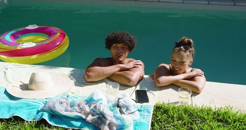 Relaxed couple lounging by vibrant backyard poolside
