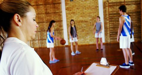 Basketball Coach Observing Training Session with Young Athletes