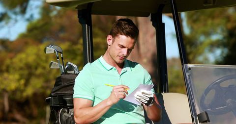 Golfer Taking Notes in Golf Cart on Sunny Day - Download Free Stock Images Pikwizard.com