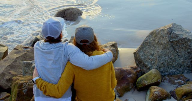 Couple Embracing on Rocky Beach Watching Waves - Download Free Stock Images Pikwizard.com