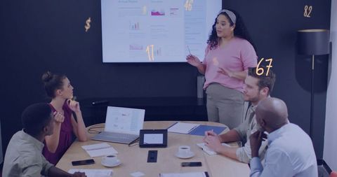 Woman presenting financial report and charts to diverse team in modern boardroom