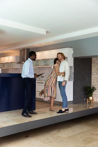 Diverse couple celebrating new home purchase with real estate agent
