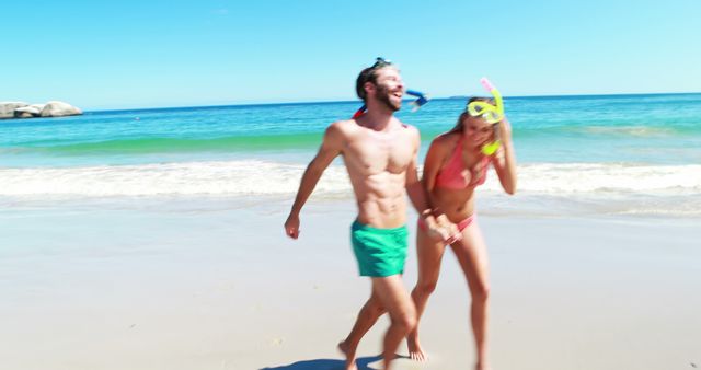Couple laughing and enjoying snorkeling on sunny beach vacation near ocean. Ideal for travel advertisements, tropical destination promotions, summer holiday features, and lifestyle blogs.
