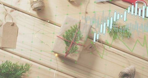 Rustic kraft gift wrapped with red twine and fir sprig on wood tabletop with data overlay