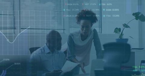 Two colleagues analyzing financial charts on laptop during collaborative office meeting