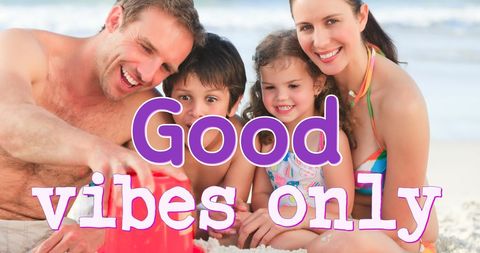 Family enjoying fun day building sandcastle at beach