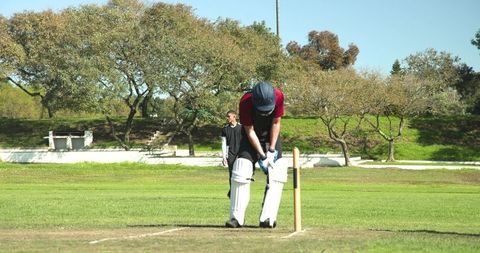 Cricket Player Perfecting Bowling Technique on Sunny Park Day