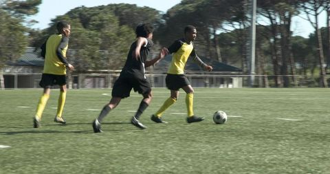 Soccer Players Competing on Open Field Wearing Yellow Kits