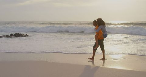 Couple Enjoying Playful Piggyback Ride on Serene Beach - Download Free Stock Images Pikwizard.com