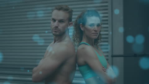 Fit Duo Posing Back to Back in Gym Light Overlay