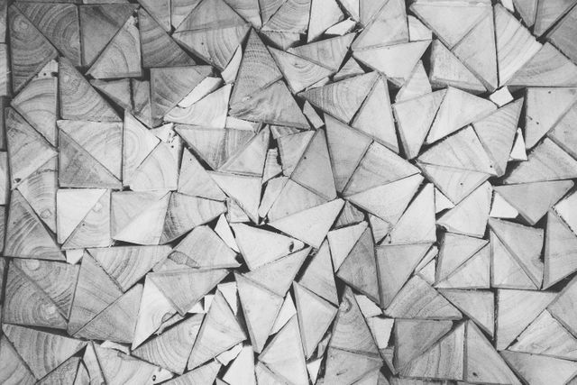 This image shows a minimalistic art design featuring interlocking triangles and squares in shades of gray. Ideal for use in modern design projects, artistic backgrounds, or any creative work requiring a unique and visually appealing pattern. Could be used in wall art, graphic design, interior decoration, or stationary design.