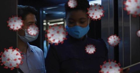 Female commuter wearing bright blue mask standing in elevator while virus particles overlay warning