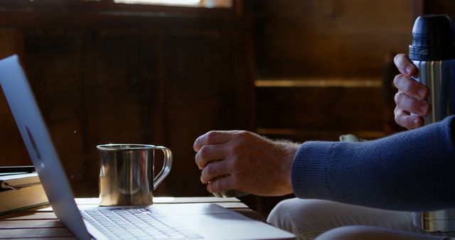 Man Relaxing in Cabin with Coffee and Laptop on Wooden Table - Download Free Stock Images Pikwizard.com