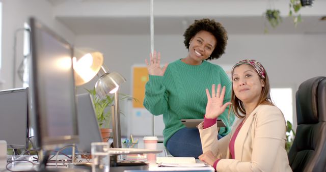 Two Diverse Women Waving at Camera in Modern Office - Download Free Stock Images Pikwizard.com