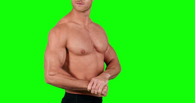 Athletic male with muscular build posing against green background. Perfect for fitness, sports, bodybuilding, and health-related content. Ideal for advertisements, fitness blogs, workout posters, and promotional materials