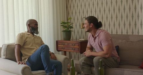 Two friends socializing with drinks in cozy living room