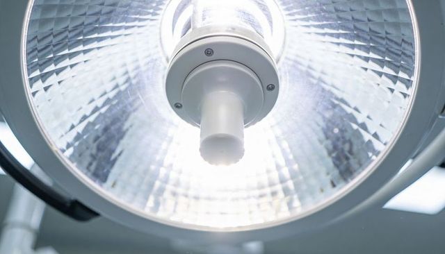 Ceiling-mounted surgical light illuminating operating room with parabolic reflector