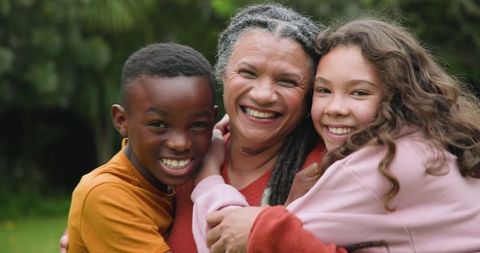 Diverse Family Embracing in Green Yard Together