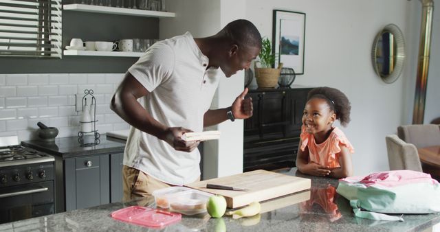 Image of african american father and daughter preparing breakfast. Enjoying quality family time together at home.