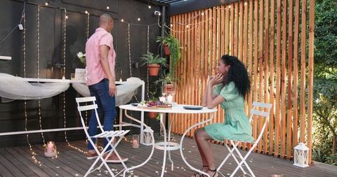 Romantic Garden Dinner with Diverse Couple Sharing Laughter