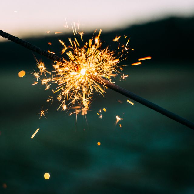 close up of a burning sparkler against dark background. festivity and celebration concept
