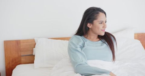 Woman in Comfortable Bedroom, Relaxing Morning in Minimalist Space