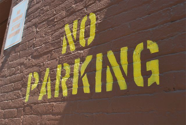 No Parking Sign Painted on Brick Wall - Download Free Stock Photos Pikwizard.com