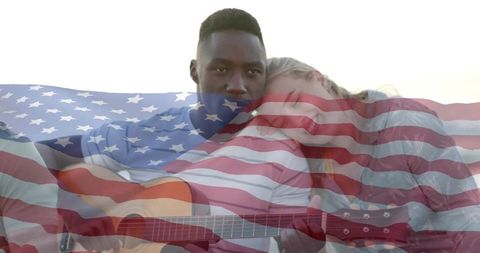 Couple playing acoustic guitar at sunset with american flag overlay for patriotic romance