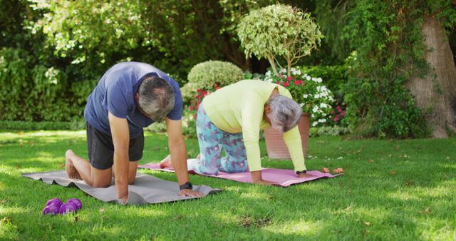Senior couple enjoying outdoor yoga in a lush garden. Ideal for illustrating concepts related to elderly fitness, healthy aging, wellness routines, and active lifestyles. Useful for health and wellness blogs, fitness guides, senior living promotions, and lifestyle magazines.