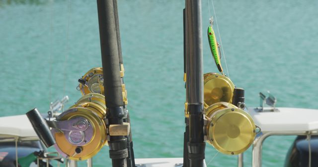 Fishing rods equipped with golden reels are seen mounted on a boat near a lake. The calm waters imply a serene and relaxing environment. Ideal for topics related to outdoor recreation, fishing, leisure activities, and boating. Can be used for articles, advertisements, or content about fishing gear and outdoor sports.
