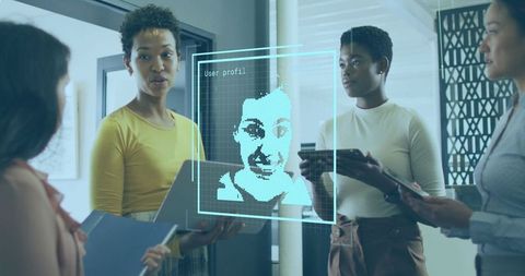 Businesswomen reviewing digital user profile hologram in modern office