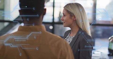 Blonde businesswoman discussing tech strategy in open-plan office with circuit hud