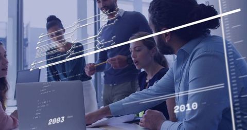 Diverse team collaborating around laptop with holographic data overlays and code
