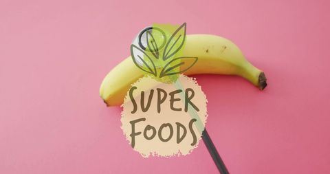 Banana with super foods text on pink background