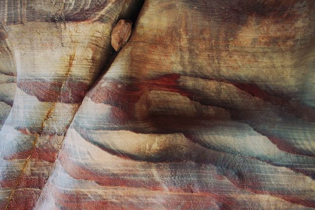 Capturing intricate natural patterns and colors of eroded sandstone rock formation. Ideal for educational materials, geology studies, nature wallpapers, and abstract art backgrounds.