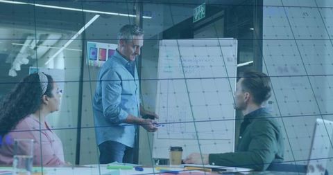 Business leader presenting strategy on flip chart during team meeting in modern boardroom