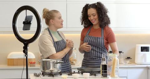 Female Friends Filming Cooking Tutorial at Home