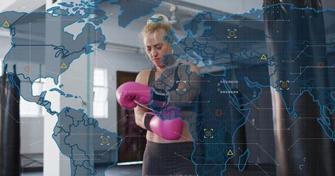 Female boxer adjusting pink gloves and wrist wraps in modern gym with global tech overlay