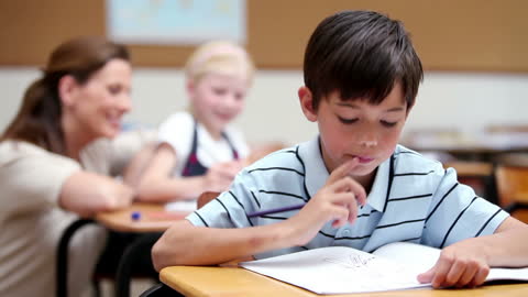 Focused Boy Engaging with Homework in Classroom