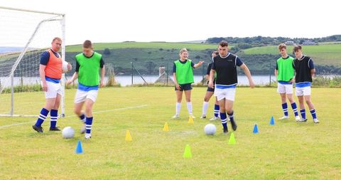 Young soccer players in outdoor team training on grassy field