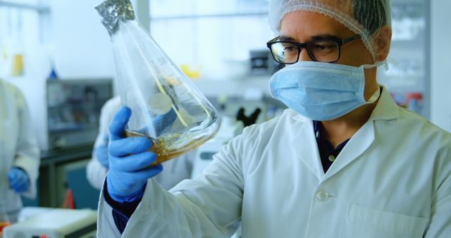 Scientist Examining Liquid in Laboratory Beaker - Download Free Stock Images Pikwizard.com
