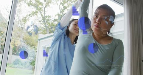 Home caregiver assisting patient with arm mobility exercises using ar health overlays