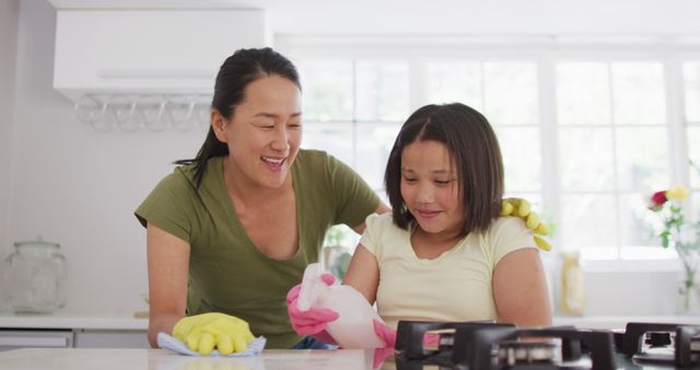 Image of happy asian mother and daughter cleaning kitchen - Download Free Stock Photos Pikwizard.com