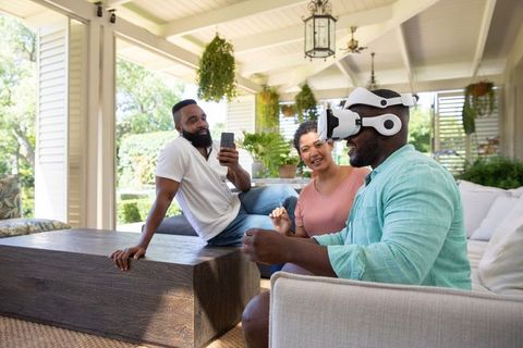 Diverse Friends Engaging in Virtual Reality Experience on Patio